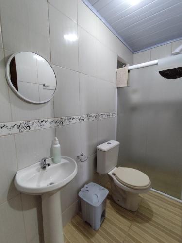 a bathroom with a sink and a toilet and a mirror at Sobrado Lar Doce Mar Itapoá 100m from the Sea in Itapoa
