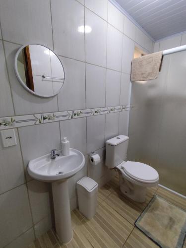 a bathroom with a sink and a toilet and a mirror at Sobrado Lar Doce Mar Itapoá 100m from the Sea in Itapoa