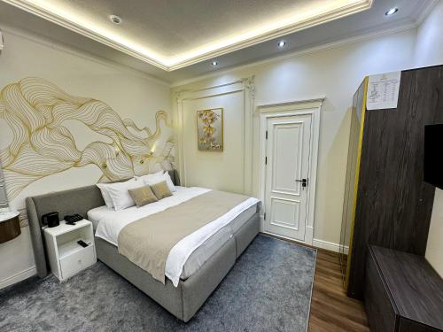 a bedroom with a bed with a painting on the wall at Qadim Hotel in Samarkand