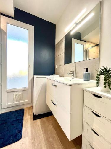 une salle de bain avec un lavabo et un miroir dans l'établissement Le refuge urbain proche des plages, à Lorient