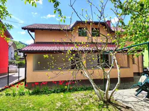 a house with red flowers in front of it at Apartment Residence House in Bihać