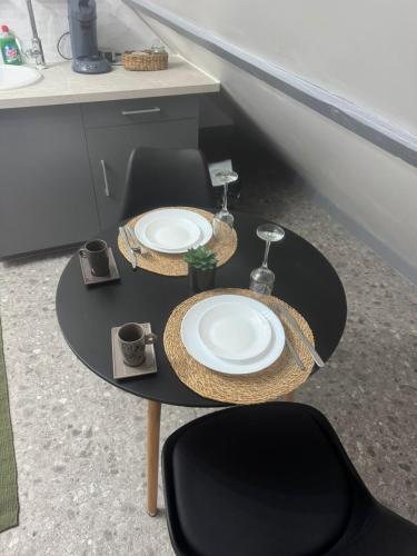 - une table noire avec des assiettes dans la cuisine dans l'établissement La détente, à La Chapelle-Saint-Mesmin