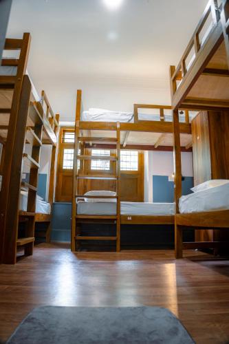 a room with three bunk beds and a rug at Leo Vishroam in Mysore