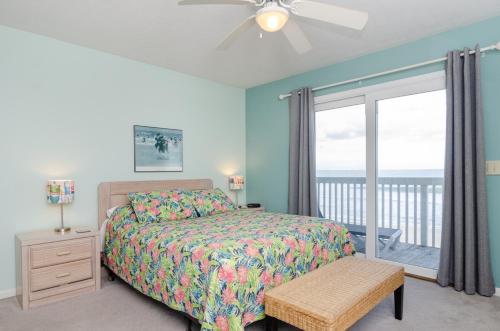 una camera da letto con un letto e una finestra con balcone di Yerby by Bryant Real Estate a Kure Beach