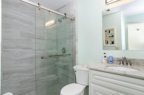 un bagno con doccia, wc e lavandino di Yerby by Bryant Real Estate a Kure Beach