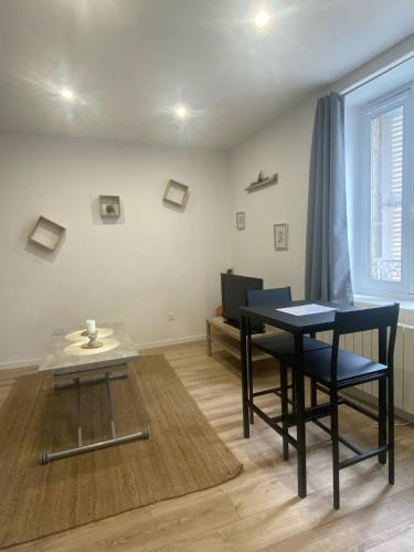 un salon avec une table, des chaises et un canapé dans l'établissement Studio Cosy - proche du centre ville, à Guingamp