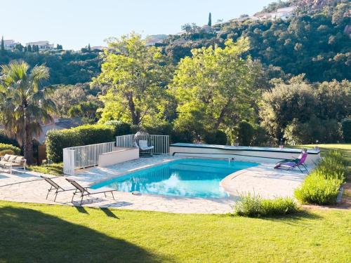 - une piscine dans une cour avec 2 chaises dans l'établissement Exclusive Authentic Riviera Villa - Private Pool, Pétanque Court, Panoramic Mediterranean Sea & Estérel Mountain Views, à Saint-Raphaël