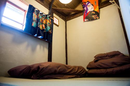 a small room with a bed and a window at Dot Hostel Nagano in Nagano