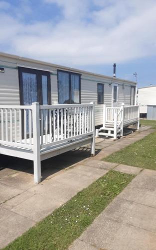 two white benches in front of a mobile home at Highfield and the Haven Caravan Skegness in Lincolnshire