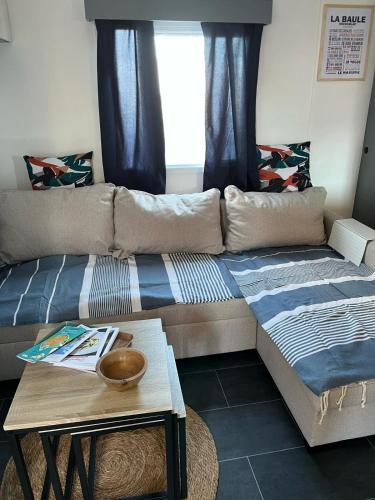 a couch and a table in a living room at Mobil-home 5 personnes in La Baule