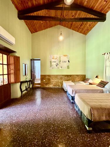a room with three beds and a piano in it at La Posada De Juan in Cabra Corral