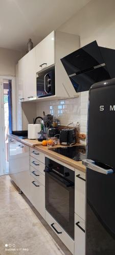 une cuisine avec des armoires blanches et un four à plaques de cuisson dans l'établissement Maison Ver Luisant, à Lège-Cap-Ferret