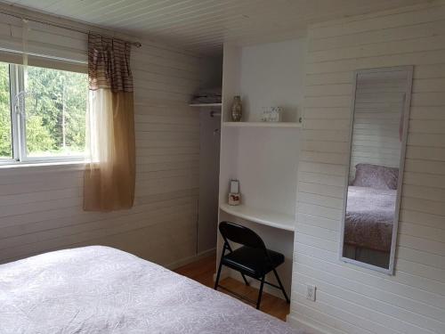 a bedroom with a bed and a desk and a window at Cozy Cabin, 2 min to the HWY1 in Tappen