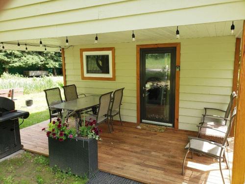 a patio with a table and chairs on a deck at Cozy Cabin, 2 min to the HWY1 in Tappen