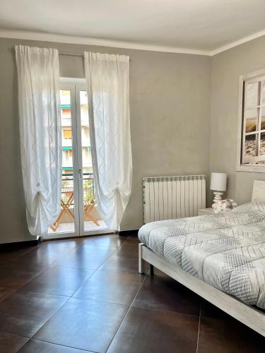 a bedroom with a bed and a large window at Le Crudi Home Genova Pegli in Genova