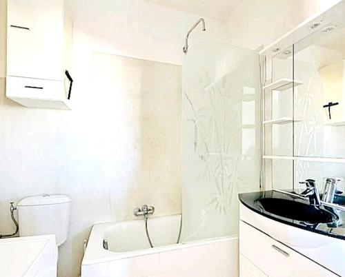 une salle de bain blanche avec un lavabo et une baignoire dans l'établissement Studio Piscine Antibes, à Antibes