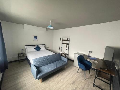 a bedroom with a bed and a desk with a computer at 1 Bed Flat with King or Twin Beds, Sofa Bed, Work space, Dining and SMART TV with Free Wifi Throughout! in Wingate