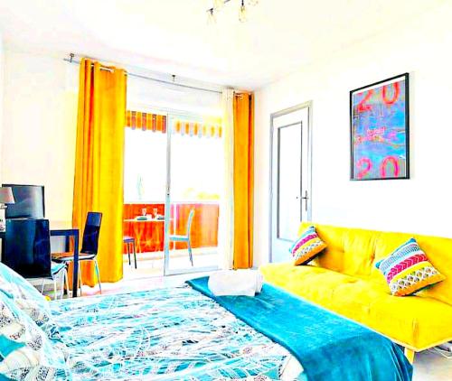 un salon avec un canapé jaune et une table dans l'établissement Studio Piscine Antibes, à Antibes