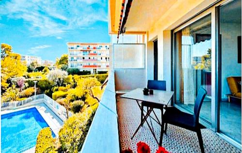 - un balcon avec une table et une piscine dans l'établissement Studio Piscine Antibes, à Antibes