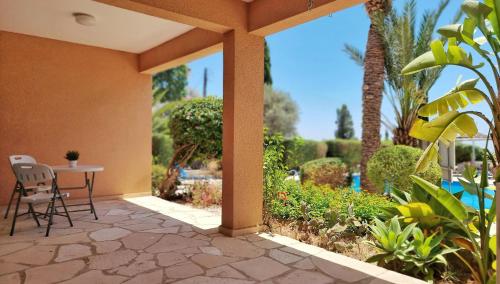 a patio with a table and chairs and a garden at CSS Cozy Smart Superior Seaview in Tala