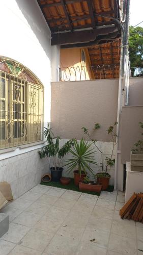 a patio with potted plants on the side of a building at Casinha da Paz in Praia Grande