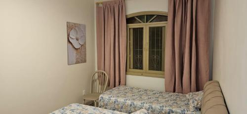 a room with two beds and a window at Casinha da Paz in Praia Grande