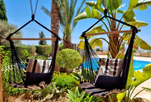 two hammocks hanging in a garden next to a pool at CSS Cozy Smart Superior Seaview in Tala