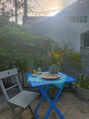 a blue picnic table and a chair in a garden at Andrebyke in Gergei