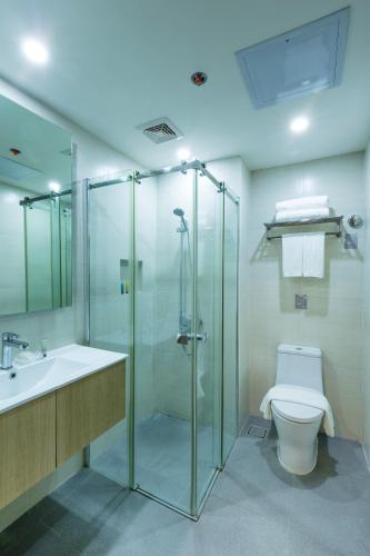 a bathroom with a shower and a toilet and a sink at Azalea Hotels & Residences Boracay in Boracay