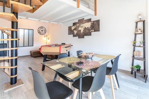 une salle à manger avec une table et des chaises en verre dans l'établissement Le Albert 1er appartements tout équipés au coeur de Béziers, à Béziers