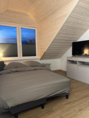 a bedroom with a bed and a flat screen tv at Apartamenty Niesiołowice na Kaszubach in Niesiołowice