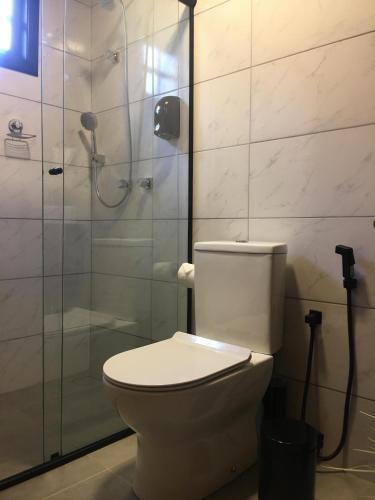 a bathroom with a toilet and a glass shower at Rancho do Tigre in São Joaquim