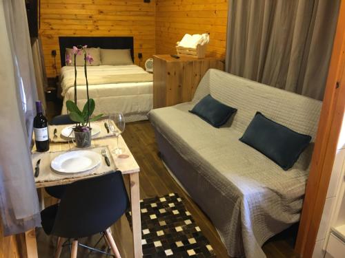 a small room with a bed and a table and a sink at Rancho do Tigre in São Joaquim