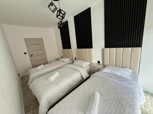 3 posti letto in una stanza con lenzuola bianche di Drahan Apartment 14 a Radom