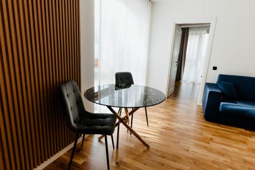 a glass table and two chairs in a living room at Evo Residence Taietura Turcului in Cluj-Napoca