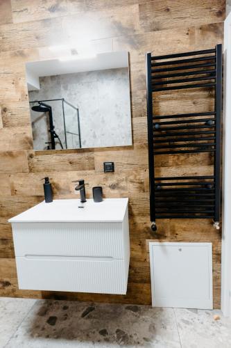 a bathroom with a white sink and a mirror at Evo Residence Taietura Turcului in Cluj-Napoca