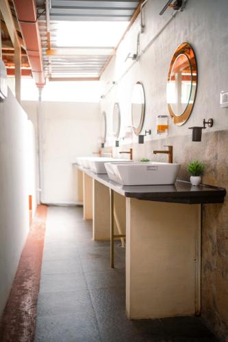 a bathroom with a row of sinks and a mirror at Leo Vishroam in Mysore