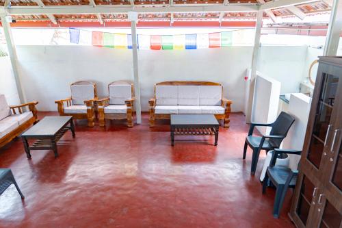 a room with chairs and benches and a table at Leo Vishroam in Mysore