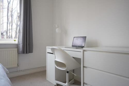 a white desk with a laptop and a white chair at Central Sheffield stylish stay in Sheffield