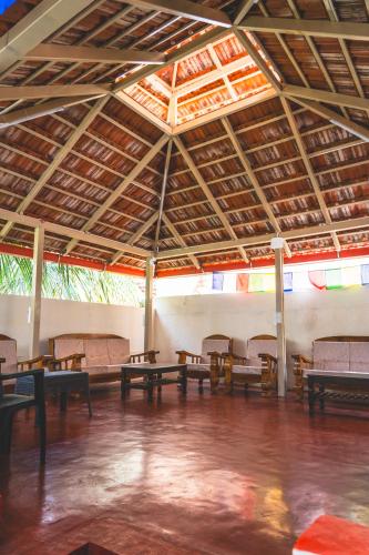 a room with tables and benches in a building at Leo Vishroam in Mysore