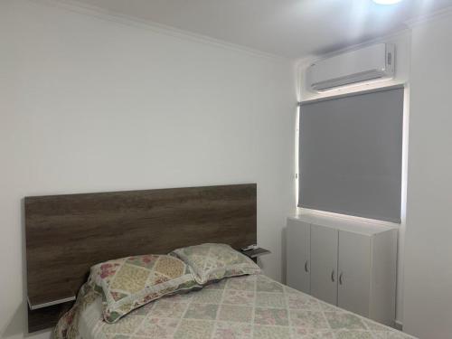 a bedroom with a bed with a wooden headboard at QQ Dpto in Monte Caseros