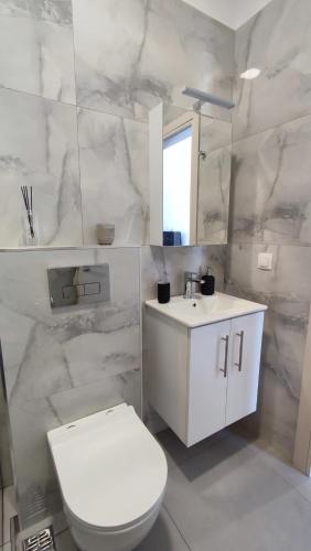 a white bathroom with a toilet and a sink at 9 keys in Skala Rachoniou