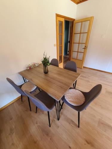 a wooden table and chairs with a vase on top at Ferienhaus Voigt in Hude