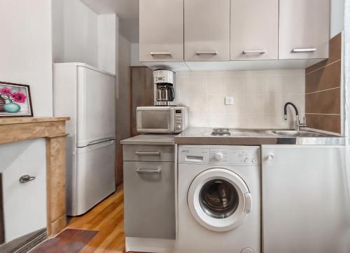 a kitchen with a washing machine and a microwave at Appartement Style London, Centre Ville in Montargis