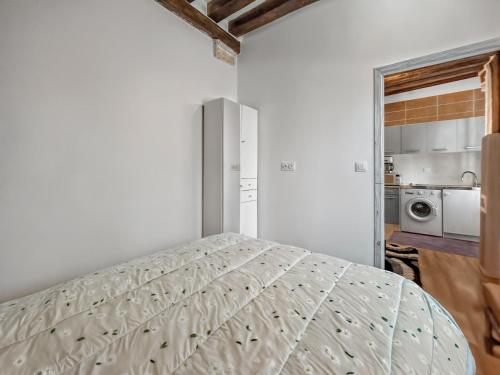 a white bedroom with a bed and a kitchen at Appartement Style London, Centre Ville in Montargis