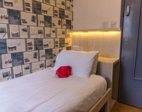 a red bag sitting on top of a white bed at La Gazelle Guest House in Butare