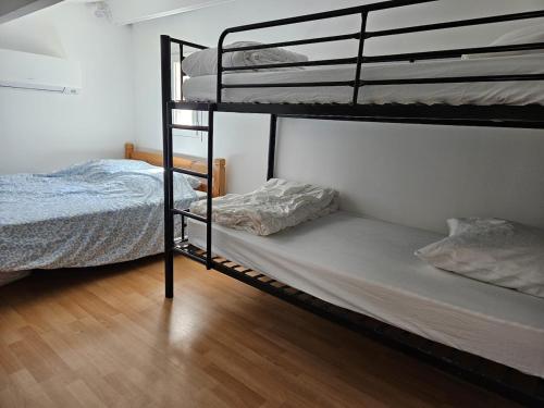 a bedroom with two bunk beds and a bed at Petite Maison de vacances in Fleury