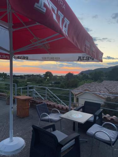 a patio with chairs and tables and an umbrella at HILL Of SAN PIETRO in Durrës