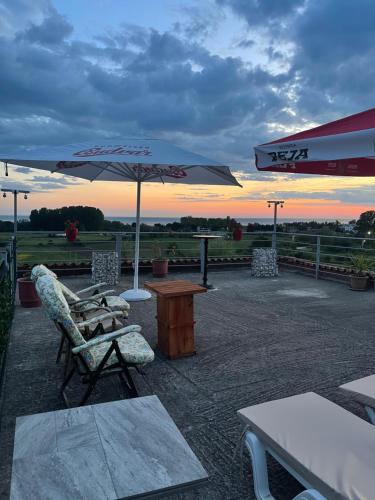 a patio with a table and chairs and an umbrella at HILL Of SAN PIETRO in Durrës