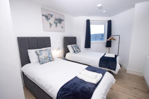 ルートンにあるMidland Apartment I 1-min walk to town centre & station I 8-mins to airport I private balconyのベッド2台と窓のある寝室